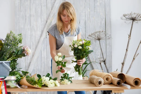 Mujer joven en floristería — Foto de Stock