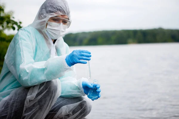 El químico toma agua para examinarla. —  Fotos de Stock