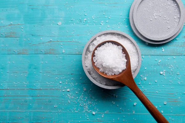 Sea salt in stone bowl and wooden spoon — Stock Photo, Image