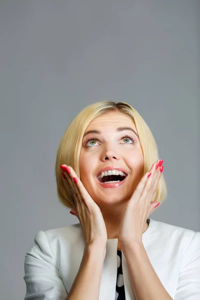 Sonriente joven rubia mira hacia arriba — Foto de Stock