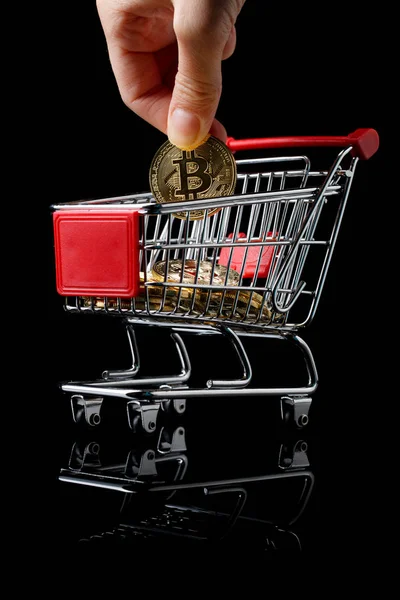 Hand kastar en bitcoin i vagn. — Stockfoto