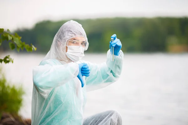 Ecologist with test-tube in mask — Stock Photo, Image