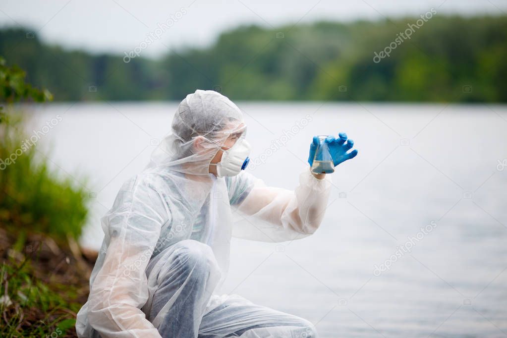 Biologist with test-tube near river