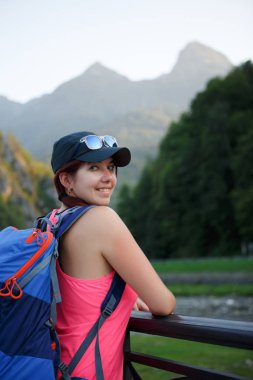 Görüntü arka plan pitoresk dağların üzerinde sırt çantası ile turist kızın