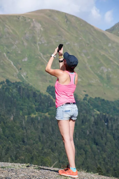 Foto von Brünette, die sich gegen den Berg fotografiert — Stockfoto