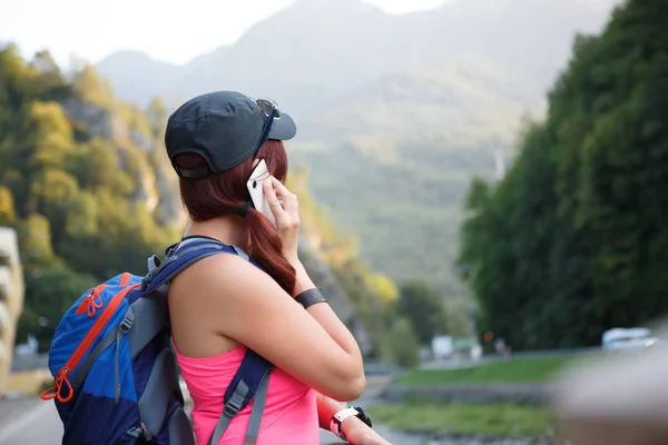 Образ ззаду туристичної дівчини, що розмовляє на смартфоні — стокове фото