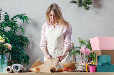 Kadın çiçekçi masaya buket oluşturma.