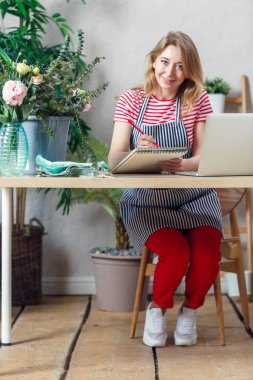 Görüntüleri çiçekçi kadın ile dizüstü dizüstü bilgisayar ile masada