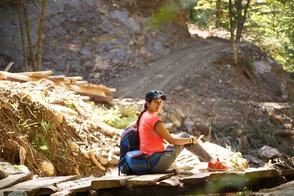 Foto der sportlich lächelnden Frau mit Rucksack im Hintergrund des Berges — Stockfoto