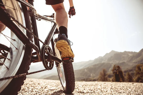 Foto de hombre en zapatillas de deporte en bicicleta en la carretera — Foto de Stock