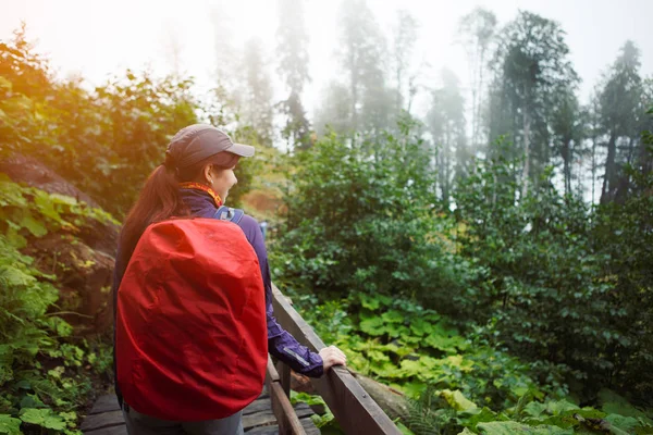 Photo of girl from back with backpack on bridge — Stock Photo, Image