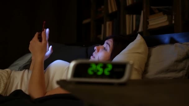 Vrouw met behulp van mobiele telefoon op bed's nachts. — Stockvideo