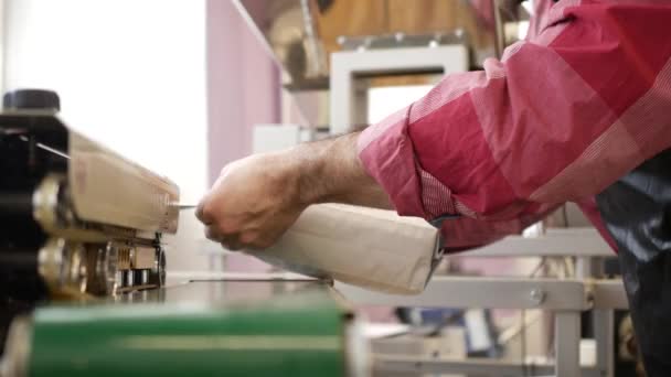 Uomo imballaggio sacchetto di caffè dalla sigillatrice in fabbrica — Video Stock