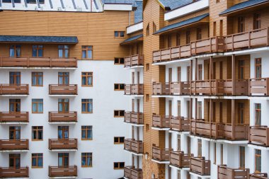 Photo of modern white building with wooden balconies clipart