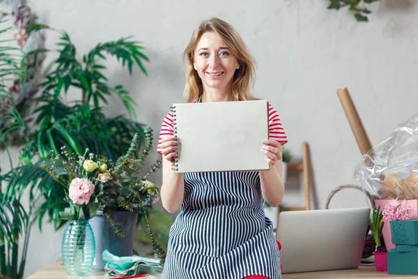 Foto de florista mulher com folha em branco de notebook — Fotografia de Stock