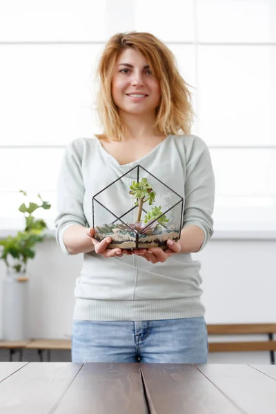 Foto der blonden Floristin mit Florarium mit Steinen und Sukkulenten — Stockfoto