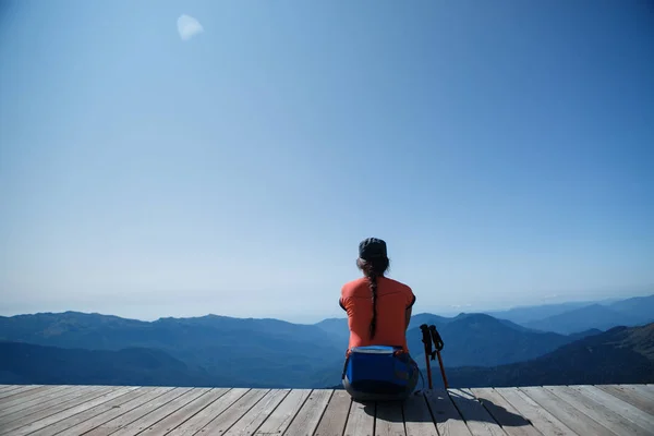 Brunette op achtergrond van berg landschap en blauwe hemel — Stockfoto