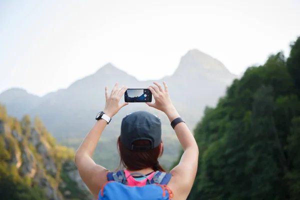 Foto von hinten von Frau mit Rucksack mit Smartphone — Stockfoto