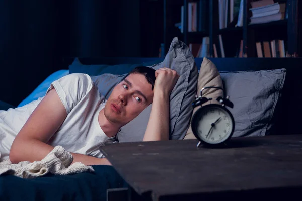 Picture of brunet with insomnia in bed with alarm clock — Stock Photo, Image