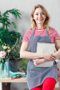 Kadın holding çiçekçi boş defter ile gülümseyen fotoğraf