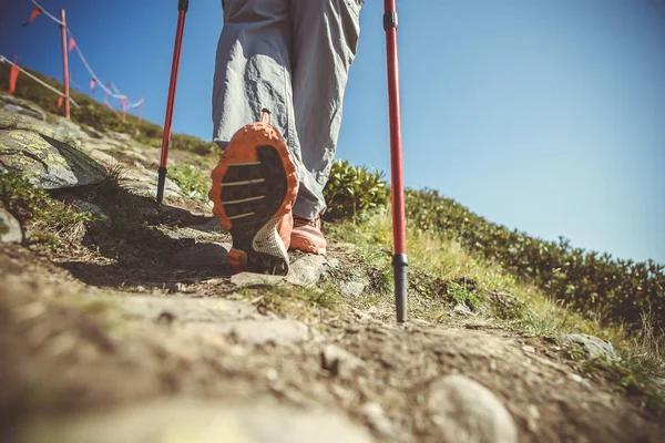 Foto de humano con bastones para paseo deportivo en las montañas — Foto de Stock