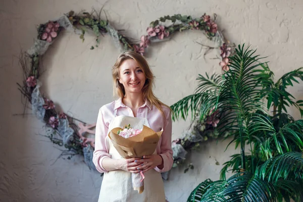 Imagen de florista sonriente con ramo en las manos — Foto de Stock