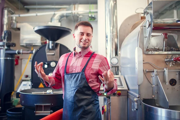 工业咖啡磨机背景下围裙上的快乐人图片 — 图库照片
