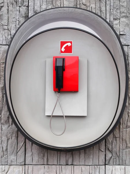 Photo of red phone on gray wall of modern building — Stock Photo, Image