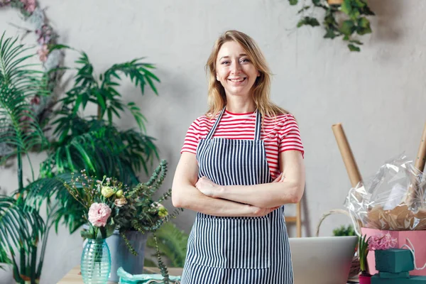 Foto de mujer sonriente con brazos de florista cruzados — Foto de Stock