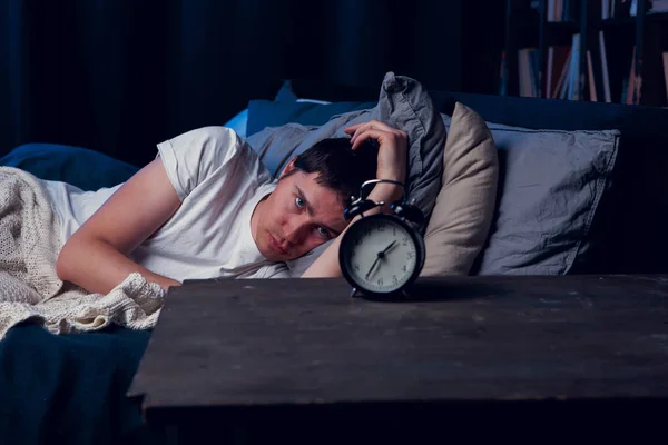 알람 시계와 함께 침대에 누워 불면증과 검은 머리의 이미지 — 스톡 사진