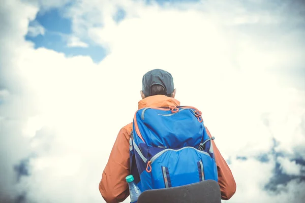 Chico de atrás con mochila sobre fondo de cielo nublado — Foto de Stock