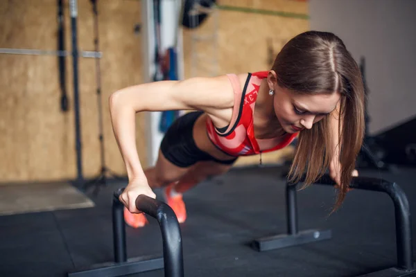 Foto van spotswoman doen horizontale push-ups met bars — Stockfoto