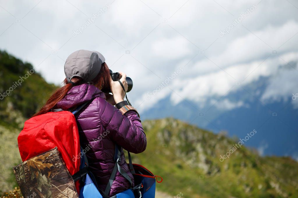 Woman photographer in sunglasses backdrop of mountains
