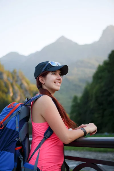 Изображение туристской брюнетки с рюкзаком на фоне живописных гор — стоковое фото