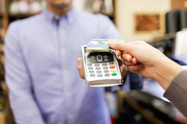 Foto do vendedor masculino com terminal na mão e comprador com cartão bancário . — Fotografia de Stock