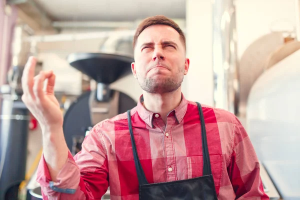 Gambar barista bahagia di celemek di latar belakang penggiling kopi industri — Stok Foto