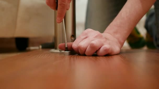 Muebles, hogar y el concepto de movimiento - primer plano de las manos masculinas montaje de las piernas a la mesa — Vídeo de stock