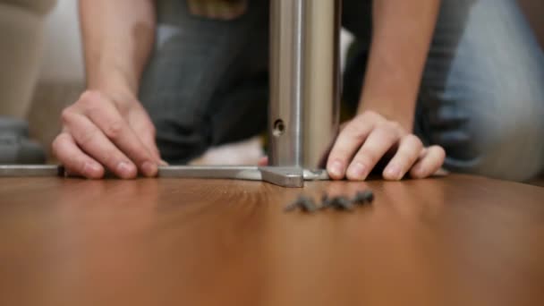 Móveis, casa e conceito em movimento - close-up de mãos masculinas montagem de pernas para mesa — Vídeo de Stock