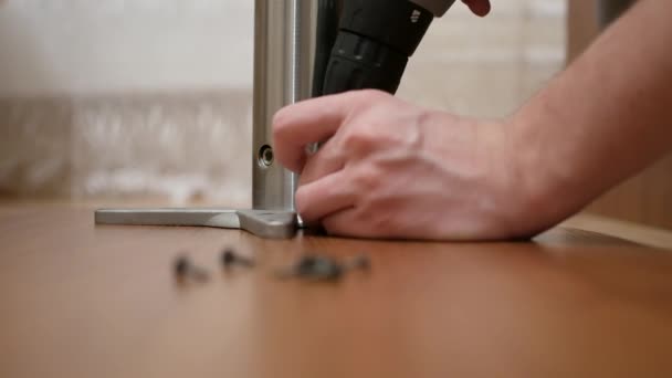 Furniture, home and moving concept - close up of male hands assembling legs to table — Stock Video