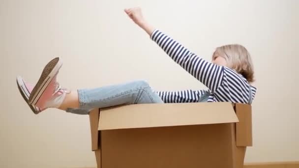 Joven mujer divertida dentro de una caja de embalaje — Vídeo de stock