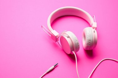 Boş pembe bir arka plan üzerinde beyaz kulaklık