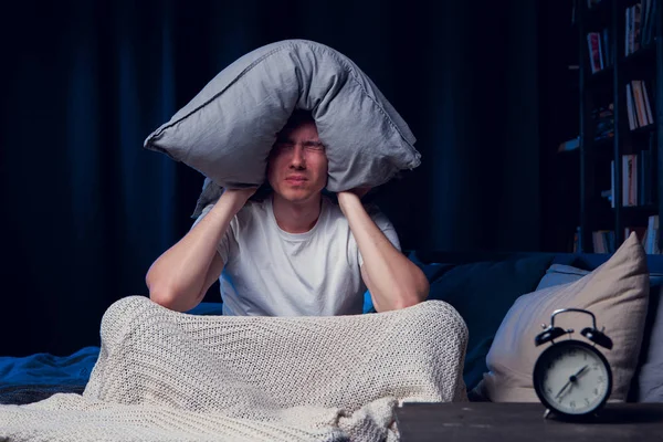 Foto do homem com insônia com travesseiro na cabeça — Fotografia de Stock