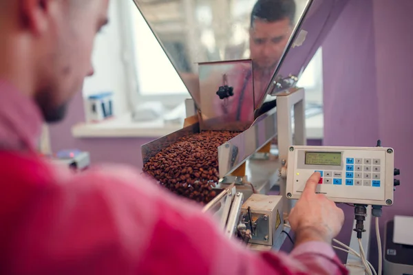 Foto do jovem empresário pesando grãos de café em balanças — Fotografia de Stock