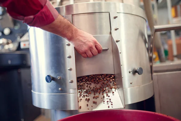 Photo of mans hand opening roaster with roasted coffee beans — Stock Photo, Image