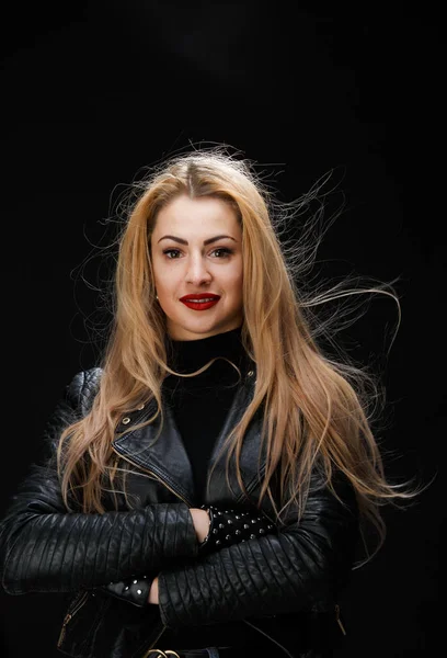 Image of young blonde in leather jacket with arms crossed at waist — Stock Photo, Image