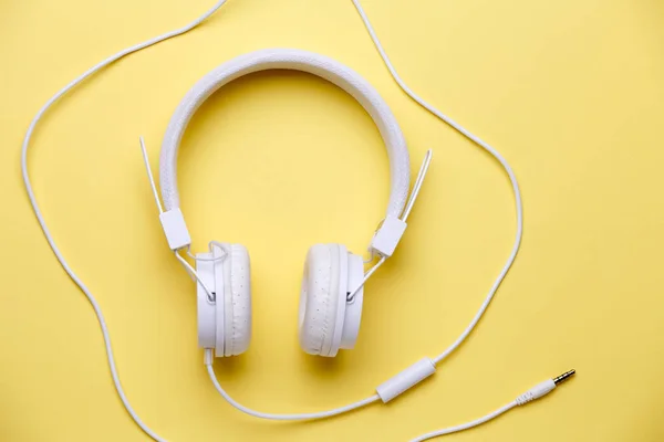 黄色の背景の音楽のための白いヘッドフォンの画像 — ストック写真