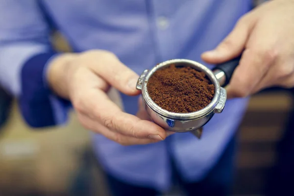 Bild eines Barista-Mannes mit gemahlenem Kaffee in der Hand — Stockfoto