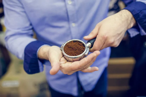 Picture of barista man with ground coffee in hands — Stock Photo, Image