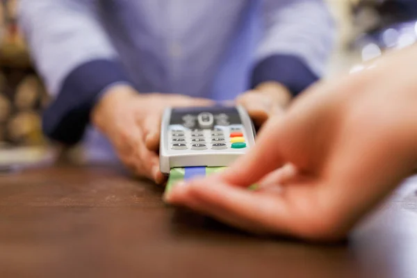 Imagem do vendedor masculino com terminal na mão e comprador com cartão bancário . — Fotografia de Stock