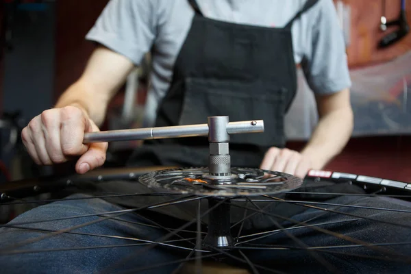 Foto van meester repareren wiel van de fiets. — Stockfoto